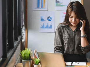 Manager takes a client cleaning request by phone at her desk — CRM for cleaning business