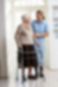Carer Helping Elderly Senior Woman Using Walking Frame