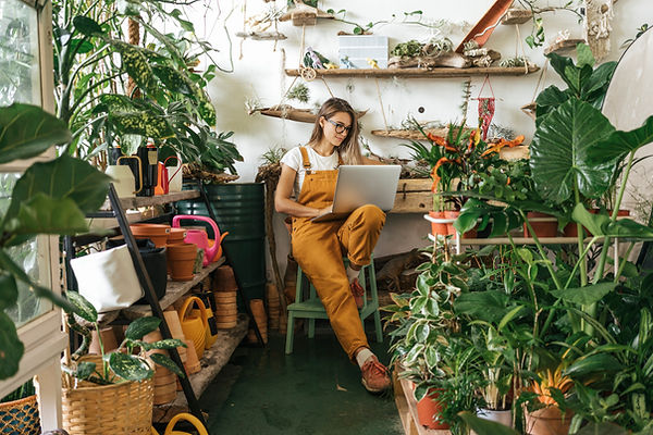 Lady sitting in hobby room surrounded by indoor plants