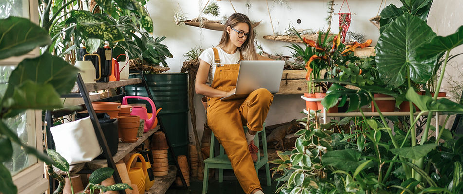Lady sitting in plant shop surrounded by indoor plants