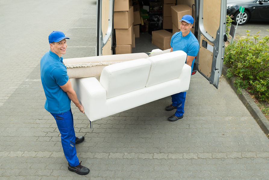 Two Happy Male Workers Putting Furniture And Boxes In Truck