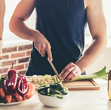 A person is chopping vegetables to prepare a meal.
