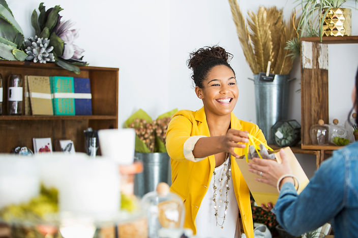 A salesperson handing a bag to a shopper