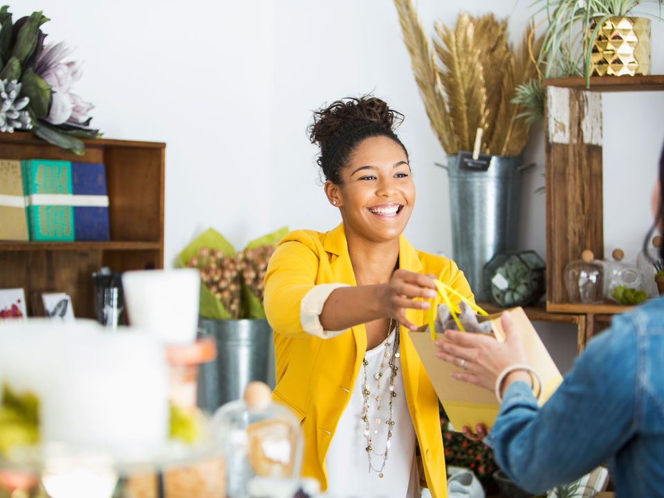 A salesperson handing a bag to a shopper