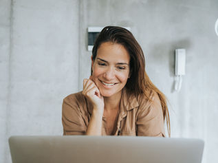 Woman smiling while looking at a laptop
