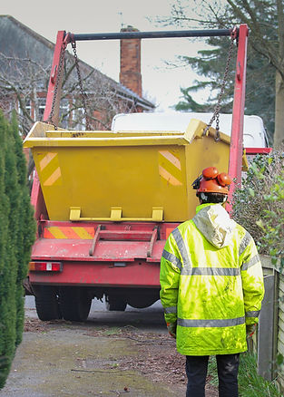 Large yellow skip being raised onto a skip lorry