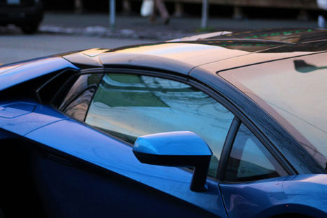 Blue sports car detail with window and side mirror at dusk background Carbon