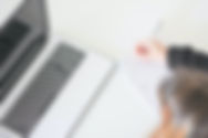 Girl taking note next to a laptop