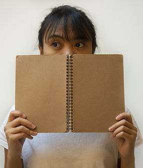 Student Hiding Behind the Notebook