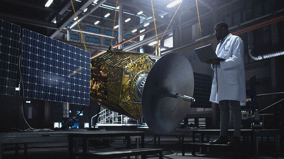Engineer Inspecting Satellite