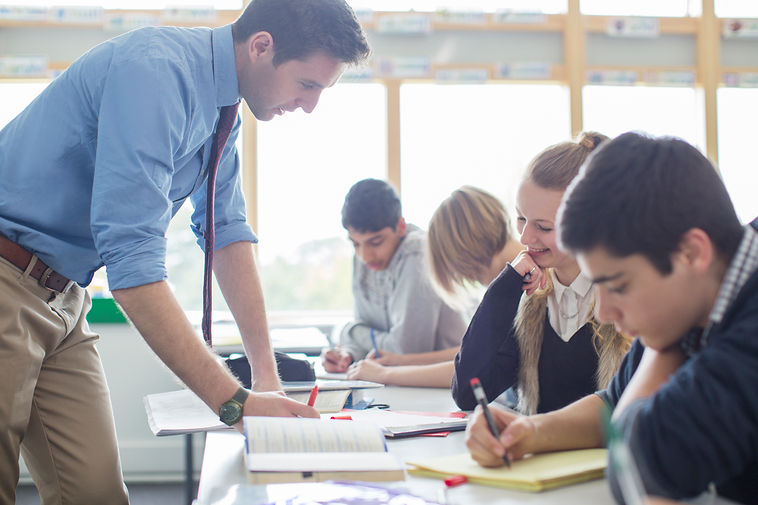 A teacher helping his students in a classroom