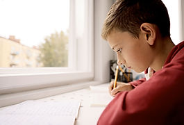 Barn som sitter fokuserat vid skrivbord efter behandling för ADHD
