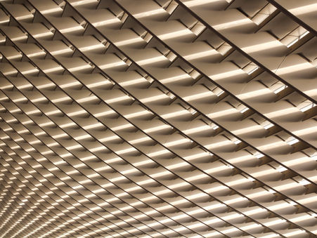 Geometric wooden slat ceiling with warm lighting