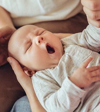 Müdes Baby wird von der Mütterpflegerin umsorgt