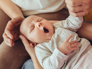 baby struggling to nap showing signs of overtired vs undertired sleep patterns in a calm nursery setting