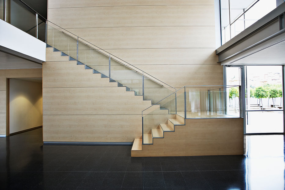 Modern interior with a sleek wooden staircase featuring glass railings