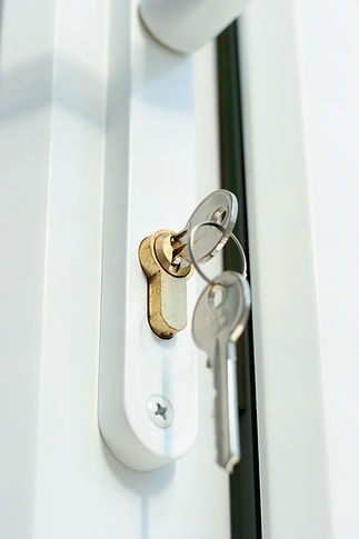 a shot of a lock and keys in a double glazed door