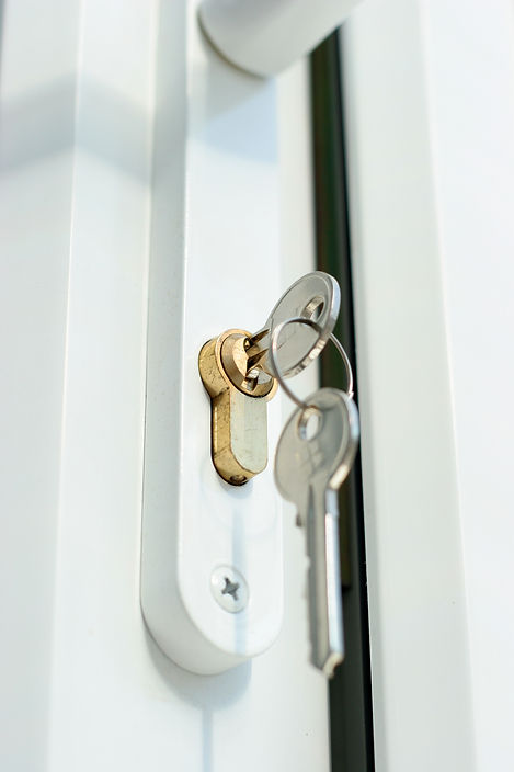 a shot of a lock and keys in a double glazed door