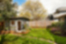 Lush green grass, a small grey garden shed