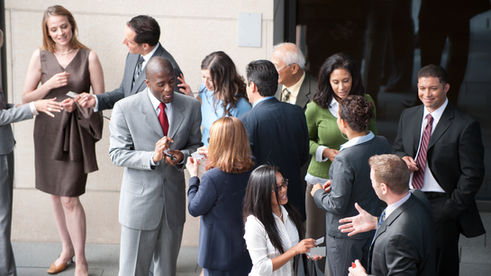 Professionals networking at a conference, illustrating confidence for networking through self-efficacy.