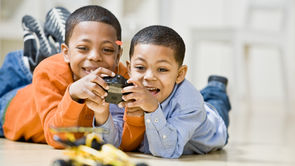 Two boys playing with motorized toy and controller