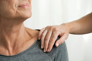 Comforting hand on senior woman's shoulder, cropped
