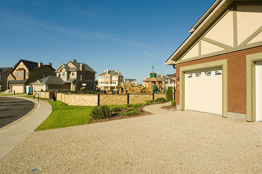Resin bound gravel driveway with landscaped border outside a suburban house