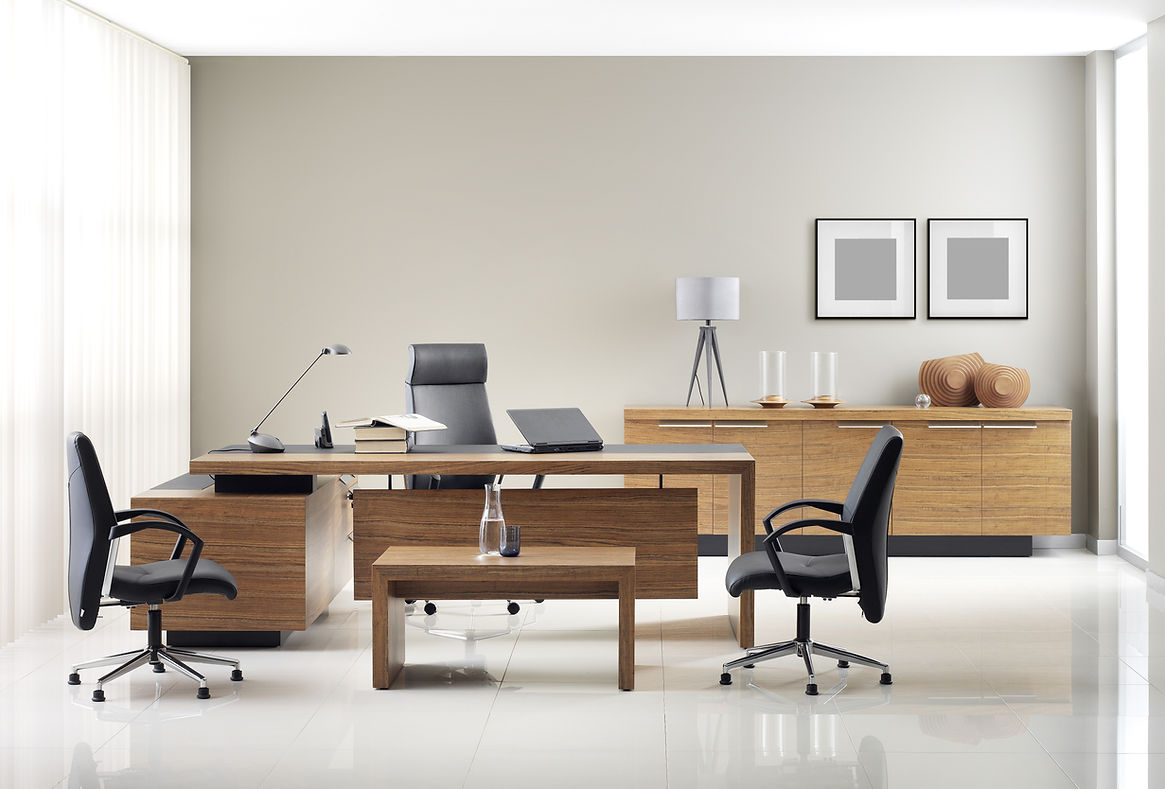 Modern office with wooden furniture, two black chairs, a desk with a lamp and laptop, and a sideboard with lamps