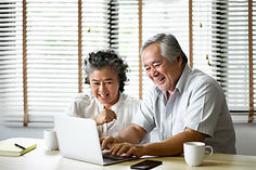 An old couple using computer happily