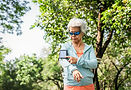 An old lady in sport outfit with sports gadget