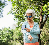 Une vieille dame en tenue de sport avec gadget sportif
