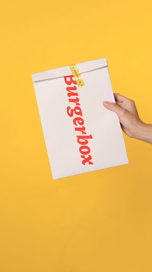 Hand holding a white paper bag