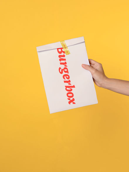 Hand holding a white paper bag
