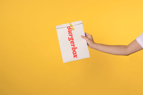 Hand holding a white paper bag