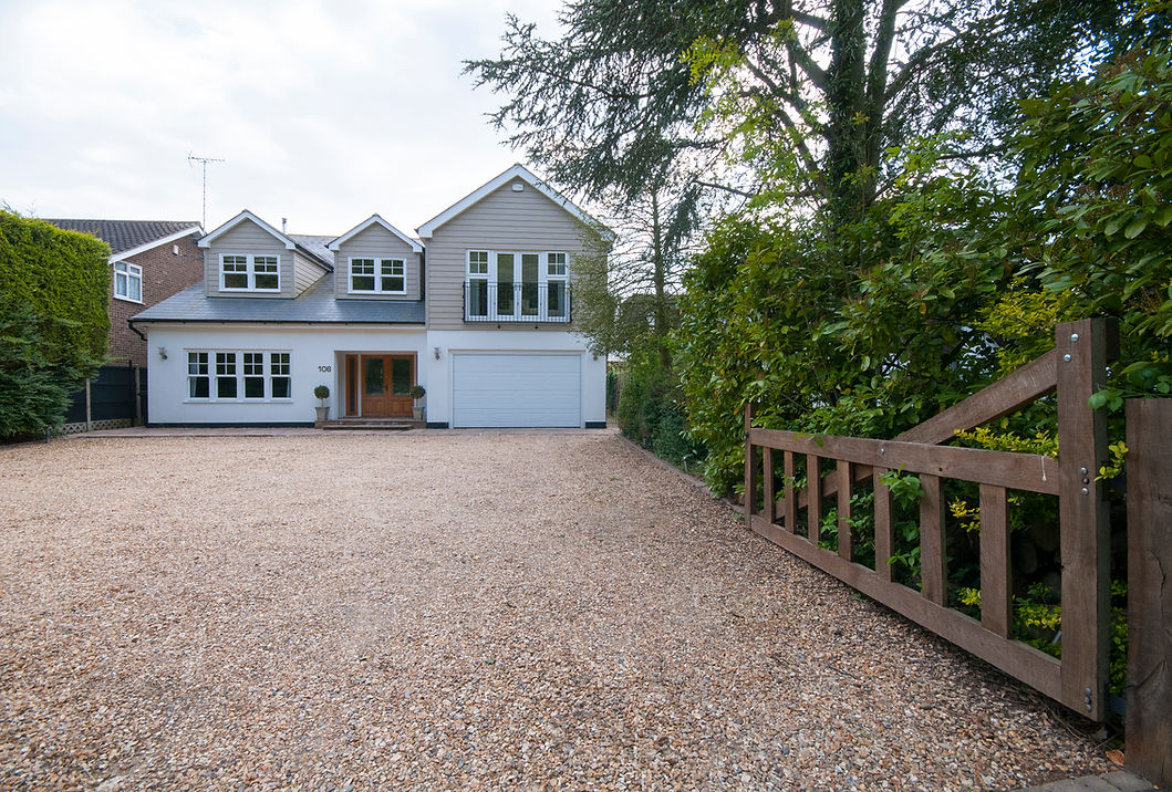 Resin bound driveway installation leading to a UK house with a timber gate