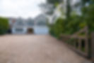 Newly laid block paving driveway in front of a white house with a timber fence