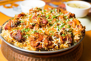 A large platter of aromatic chicken biryani garnished with herbs