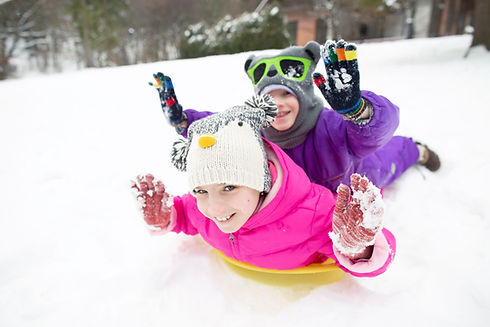 Happy Children Sledding in Snow
