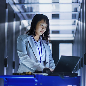 Female employeee working in a server room