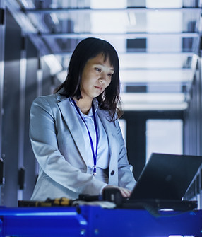 Female employeee working in a server room