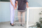 歩行器で歩く男性