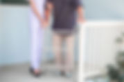 歩行器で歩く男性