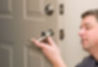 A man is installing a silver door handle on a beige door