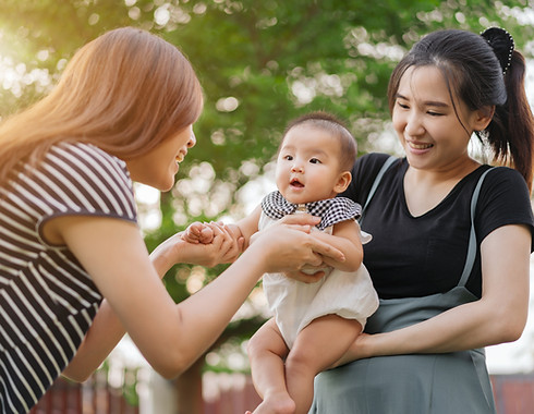 Two women playing with a baby