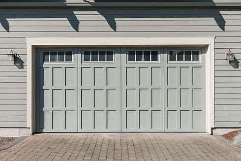 Straight on perspective of a craftsman garage door with mid-morning shadows from eaves abo