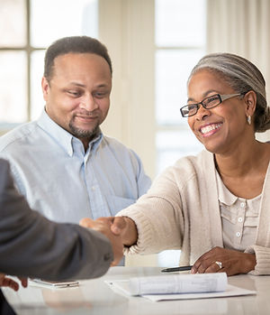 African American couple shaking hands with businessman