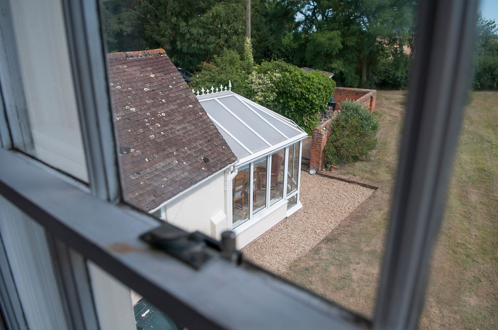 High-angle view through an open window looking down at a patio