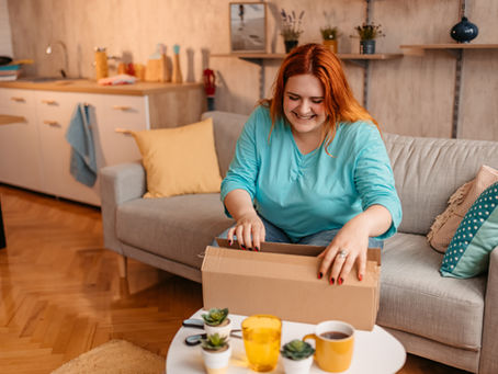 a woman smiling, opening a package