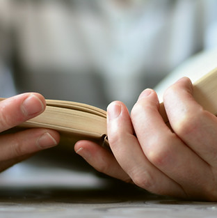 Hands opening a book, symbolizing a commitment to personal growth, learning, and self-development.
