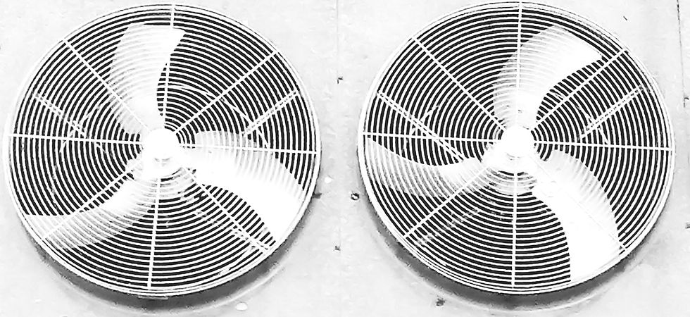 Two large industrial fans with circular grilles are mounted on a wall
